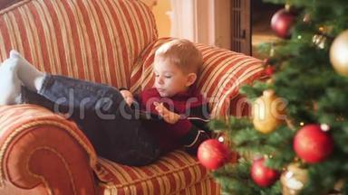 小男孩躺在客厅沙发上用平板电脑的4k视频。 <strong>儿童</strong>在<strong>寒假</strong>和